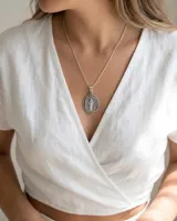 Dije de plata 925 con la imagen de la Virgen Milagrosa, de diseño ovalado con borde ornamentado.