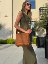 Bandolera de diseño simple con tapa frontal, confeccionada en material símil cuero. Cuenta con correa ajustable, división interna y bolsillos internos para mayor organización.