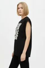 Remera negra de algodón, con cuello redondo, mangas cortas holgadas con vuelta y estampa floral grande en el pecho.