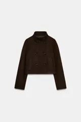 Chaqueta corta de paño color marrón, con cuello subido, manga larga y cierre frontal cruzado con botones. Presenta bolsillos delanteros de vivo.