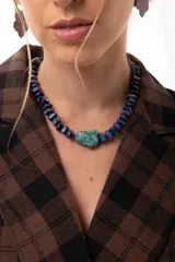Collar corto compuesto por cuentas de piedras naturales en tonos azules y una piedra central de turquesa. Incluye cadena de alargue para ajustar el largo.