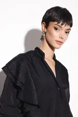 Camisa negra de nylon con cuello mao y volados de poliéster en el hombro.