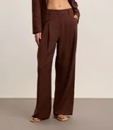 Pantalón wide leg de tiro alto color marrón chocolate, confeccionado en tejido de lino y viscosa. Incluye cinturón de cuero sintético con hebilla metálica.