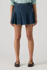 Minifalda de denim azul oscuro con diseño de godets que crean un efecto plisado y acampanado. Presenta costuras visibles y un corte estructurado.