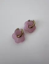 Aros de acero quirúrgico hipoalergénico con argolla dorada y dije colgante en forma de flor color violeta.