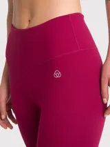 Calza deportiva de tiro alto con largo al tobillo, confeccionada en tela técnica de color bordó. Presenta un ajuste ceñido y costuras reforzadas para mayor comodidad durante el entrenamiento.