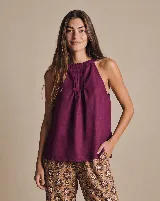 Blusa de lino color bordó, con escote halter y fruncido en el cuello. Presenta tabletas estructuradas en el frente y un diseño amplio y fluido sin mangas.