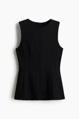 Top negro sin mangas en punto roma, modelo entallado con costuras moldeadoras, cierre oculto en la espalda y diseño de peplum.