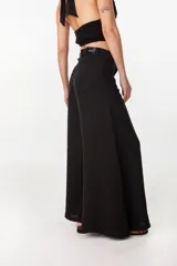 Pantalón de lino verde militar, de tiro alto y corte amplio con botamanga ancha. Cuenta con bolsillos delanteros aplicados y cierre frontal con botón y bragueta.