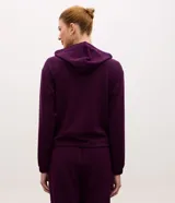 Campera deportiva de modal negro con capucha, cierre frontal por cremallera, cordones ajustables, bolsillos y mangas largas con puños elásticos.