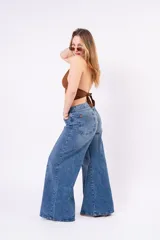 Jean de corte wide leg con costura central vertical en ambas piernas. Presenta un tono denim clásico, tiro medio y cierre frontal con botones.