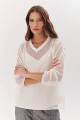 Sweater de tejido de punto calado color lila, con cuello en V y mangas largas.
