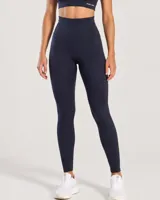 Calza deportiva larga de color negro, de tiro alto y diseño modelador, confeccionada con tejido de alta elasticidad y tacto suave.