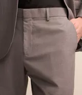 Pantalón de vestir modelo sastre, color gris con textura melange, de corte recto y estructurado. Cuenta con cintura con trabillas, cierre frontal tradicional y bolsillos laterales.