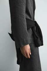 Pantalón de corte relaxed fit confeccionado en tejido 100% lino. Presenta cintura con cierre de cremallera y botón, pliegues frontales, bolsillos laterales y bolsillos traseros de vivo.