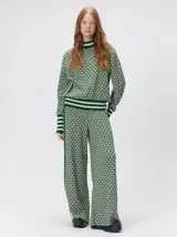 Sweater de tejido de punto jacquard con diseño geométrico, cuello redondo y puños acanalados en contraste de color verde y beige.