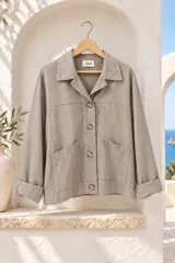 Chaqueta de gabardina elastizada color gris, con cuello camisero, cierre frontal de botones, bolsillos frontales parche y mangas largas con vuelta.