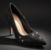 Zapato stiletto de tacón alto en color negro, completamente cubierto de pequeños cristales brillantes. Presenta una silueta clásica con punta fina y un diseño elegante ideal para eventos nocturnos.