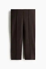 Leggings capri en punto grueso color marrón, con elástico oculto en la cintura y pliegue cosido adelante y atrás. Presenta una abertura corta en los bajos.
