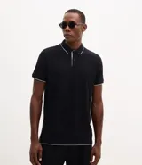 Polo de manga corta confeccionada en algodón de media malla, color negro con detalles en blanco en el cuello y los bordes de las mangas. Presenta cuello polo tradicional y cierre frontal con botones.