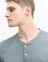 Camiseta de manga corta color verde agua, con cuello redondo y tapeta de dos botones.