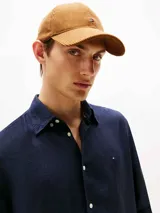 Camisa de manga larga color azul marino, confeccionada en lino pigmentado con un acabado ligeramente desgastado. Presenta cuello clásico con botones y el logo de Tommy Hilfiger bordado en el pecho.