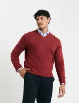 Sweater de punto color ladrillo con cuello en V y mangas largas.
