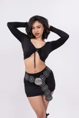 Minifalda negra ajustada al cuerpo con cinturón de cuero sintético con apliques metálicos.