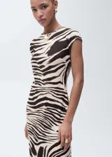 Vestido midi de corte recto con estampado de cebra, cuello redondo y mangas cortas. Confeccionado en tejido elástico con cierre de botón en la parte posterior.