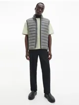 Chaleco gris con cierre frontal, cuello alto y bolsillos laterales con cierre.