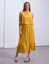 Vestido largo blanco de crepe con escote redondo y detalle de crochet en los hombros. Tiene corte en la cintura con punto smock.