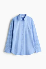 Camisa oversize de popelina a rayas celestes y blancas, con cuello clásico, mangas largas, bolsillos en el pecho y cierre frontal de botones.