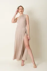 Vestido largo de lurex plisado color marfil, con un solo hombro, falda abierta con short incorporado.