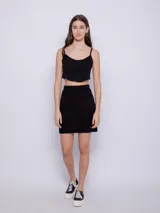Minifalda negra de tejido de punto con pretina elástica y abertura lateral.