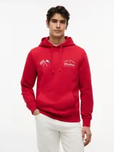 Buzo con capucha de Tommy Hilfiger en colaboración con Cadillac Formula 1 Team. Confeccionado en algodón, presenta un diseño de color rojo con bolsillo tipo canguro, puños y bajo acanalados. Incluye bordados en el pecho con banderas cruzadas y el logo de la colaboración.