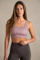 Top deportivo de escote redondo y espalda estilo nadadora, confeccionado en tejido técnico con estampado abstracto en tonos rosados.