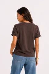 Remera de manga corta color beige, con cuello redondo y diseño al cuerpo. Presenta un estampado frontal multicolor de estilo veraniego con temática marina y detalles con glitter.
