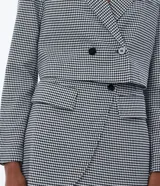 Blazer corto con estampado de pata de gallo en blanco y negro, con cuello solapa, cierre cruzado con botones y bolsillos delanteros simulados.