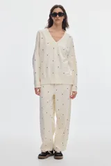 Buzo de felpa sin frisa color marfil con estampado de lunares negros, escote en V y diseño holgado.