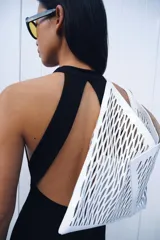 Vestido largo de corte fluido con cuello halter y espalda descubierta. Presenta un detalle de drapeado lateral y bajo recto.