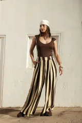 Pantalón sastrero de corte ancho con diseño de rayas verticales en tonos marrón y beige, pinzas frontales y bolsillos laterales.