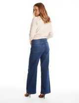 Jean de tiro alto con corte wide leg y pierna ancha. Presenta cierre frontal con botón, pasadores para cinturón y bolsillos funcionales en la parte delantera y trasera.