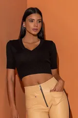 Blusa corta negra de tejido de punto, con escote en V y mangas cortas.