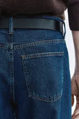 Jean de cinco bolsillos en denim de algodón rígido, con cintura clásica y cierre de botones. Modelo de corte relajado y piernas rectas.