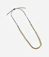 Collar corto con diseño trenzado que combina cadena metálica dorada y cordón negro de poliéster.