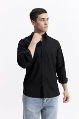 Camisa clásica lisa de manga larga color negro, con cartera abotonada, logo bordado en el pecho y fit slim.