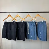 Bermuda de jean estilo jogger con efecto desgastado, roturas frontales y ruedo desflecado.