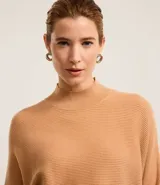 Blusa de punto acanalado color tostado, con cuello alto, mangas largas y puños ajustados. Confeccionada en viscosa, poliéster y poliamida.