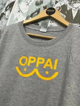 Remera gris con estampado amarillo de la palabra "OPPAI" con un diseño que simula senos.