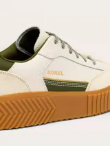 Zapatillas Sorel modelo Ona Ave T-Toe con diseño retro y plataforma. Presentan una combinación de cuero y gamuza en tonos crema, con detalles en verde oliva y suela de caucho color caramelo con textura estriada.